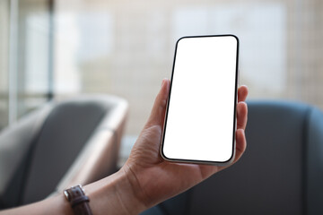 Mockup image of a woman holding and using mobile phone with blank desktop screen
