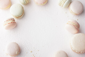 Fototapeta na wymiar Pastel colored macaroons on a white background with copyspace