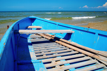 Fototapeta na wymiar Small blue rowing boat on the seashore