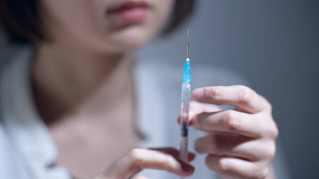 60p　注射を打つ女性（薬物中毒・薬物依存症・ドラッグ）