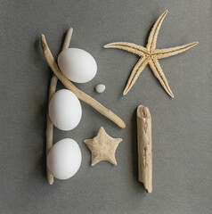 White eggs in an Easter composition with starfish and sticks from the sea