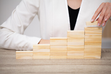 Fingers climbing the stairs made with wooden blocks.