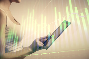 Double exposure of forex chart sketch hologram and woman holding and using a mobile device. Financial market concept.