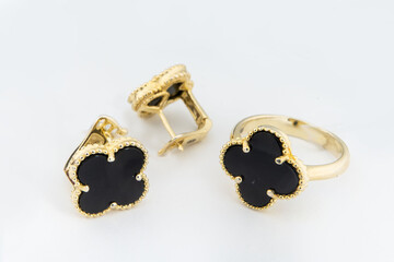 Gold jewelry set of ring and gold earrings with stones on white background. Gold jewelry set collection