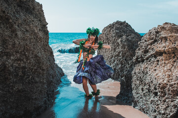 Woman shaking hips between rocks. Gorgeous woman dressed in traditional Hawaiian dance attire...