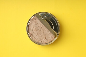 Tin can of pate on yellow background