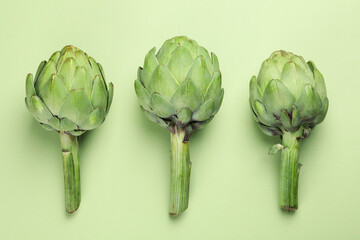 Concept of healthy food with artichoke on green background