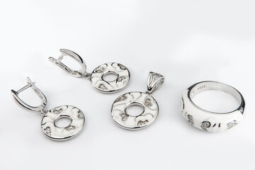 Silver jewelry set of ring and silver earrings with stones on white background. Silver jewelry set collection