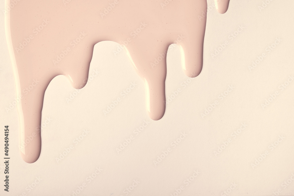 Sticker light brown liquid drops of paint color flow down on beige background. abstract cream backdrop with 