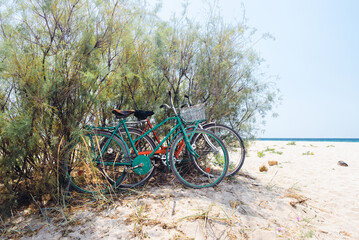 Fototapeta na wymiar Old style bicycles parking in the shadow on beach