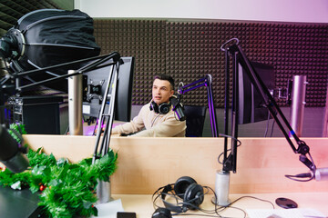 A sports speaker is preparing to conduct a live broadcast in a radio studio.