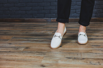 Close-up female legs in black trousers and leather beige moccasins. New spring-summer collection of...
