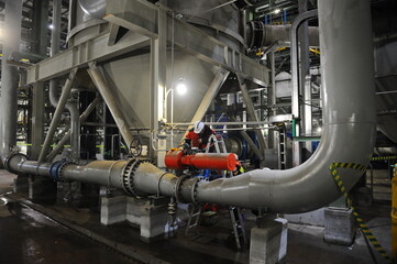 Pavlodar region, Kazakhstan - 12.10.2015 : A worker tightens the bolts on a pipe in production
