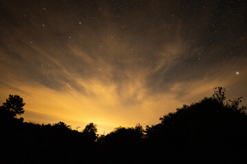 Fototapeta na wymiar Orange night lights in the star sky long exposure photography