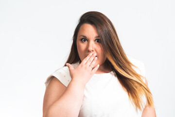 portrait of a chubby young woman with her hand covering her mouth.