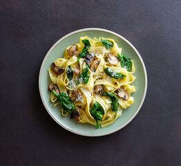 Linguini pasta with mushrooms, spinach and cheese. Healthy eating. Vegetarian food. Italian cuisine.