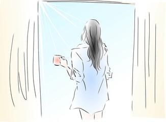 朝日を浴びながらコーヒーを飲む女性
