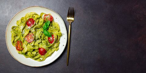 Linguini pasta with pesto sauce, tomatoes and cheese. Healthy eating. Vegetarian food. Italian cuisine.