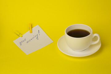 Obraz na płótnie Canvas white cup on a yellow background with a note of a good day