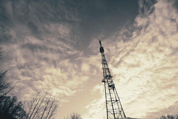 a television cell tower on the border of two states against a blue sky, the front and back...