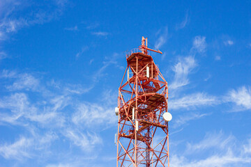 a television cell tower on the border of two states against a blue sky, the front and back...