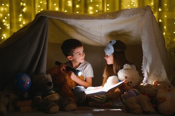 Obraz na płótnie Canvas Little children reading bedtime story at home