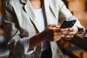 Crop close up of African American woman hold cellphone text message online on gadget. Ethnic biracial female use smartphone browse surf wireless internet on device. Technology, communication concept.