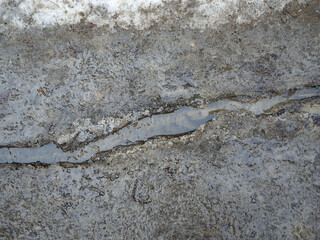 Trickle water closeup on icy surface in Russia.