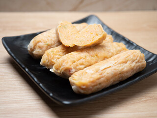 Stack of shrimp egg rolls on a black square bowl