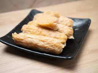 Stack of shrimp egg rolls on a black square bowl