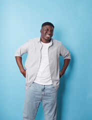 An African-American man in white clothes stands on an isolated blue background