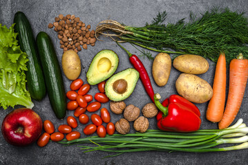 Healthy food background. Healthy vegetarian food. Vegetables and fruits on black stone. Clean vegetarian eating concept.