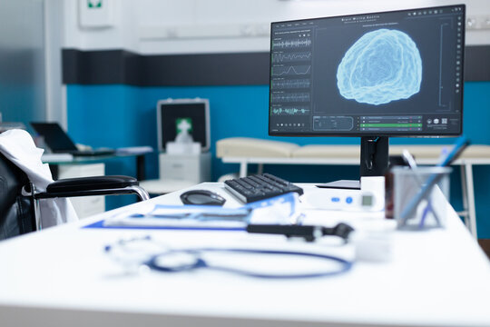 Computer standing on table having brain radiography on screen during oncology examination. Empty hospital office equipped with medical professional instruments. Health care services support