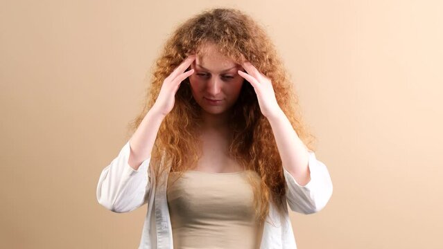 Young woman fottball fan with red hair touching her temples with hands, she can not beleive her team lost the game.