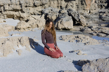 Young woman practice balance asanas on Summer yoga session on a beautiful beach at Formentera, Spain