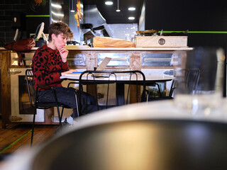 Worried woman working in the management of a restaurant with a laptop