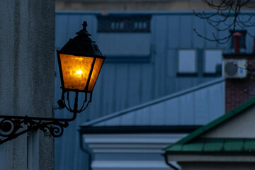 Fototapeta na wymiar Zapalona stara zabytkowa latarnia, wieczór.