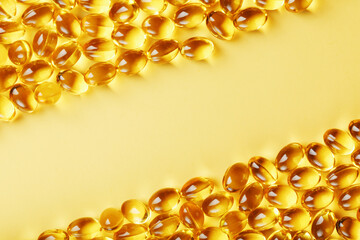Capsules in a shell with liquid vitamin D3 on a yellow background and a place for text