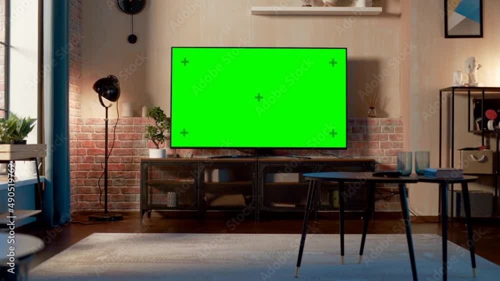 Poster stylish loft apartment interior with tv set with green screen mock up display standing on television