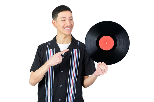 Happy Guy Holding A Vinyl Record And Pointig It. Isolated On White Background. 18-20 Years Old Latin American Guy.