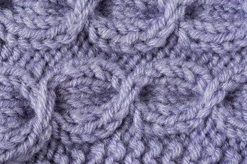 Knitted texture background. Hand-knitted wool. Macrophotography of a thread drawing. Gray-lilac texture of sweaters, pullovers, cardigans. Abstract natural background. Comfort autumn warmth concept