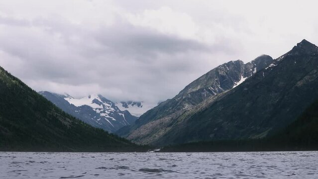 Timelapse video of a mountain lake on a cloudy day. Atmospheric landscape of fishing and hiking