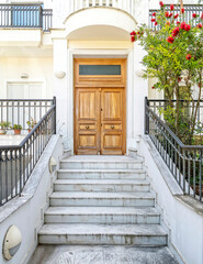 contemporary house entrance with white marble stairs and brown natural wood door