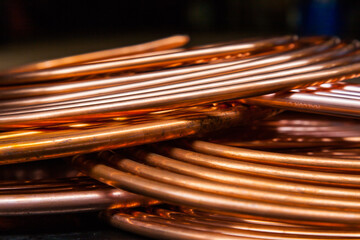 Twisted new copper tubes on a black background.