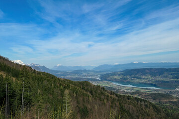 Scenic view on the Drava river in the Rosental valley on the way to Sinacher Gupf in Carinthia, Austria. Forest in early spring. The Hohe Tauern mountain range can be seen in the back. Sunny day. Hike