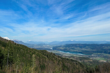 Scenic view on the Drava river in the Rosental valley on the way to Sinacher Gupf in Carinthia, Austria. Forest in early spring. The Hohe Tauern mountain range can be seen in the back. Sunny day. Hike