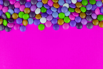 Multicolored candies on a pink background.Copy space.	