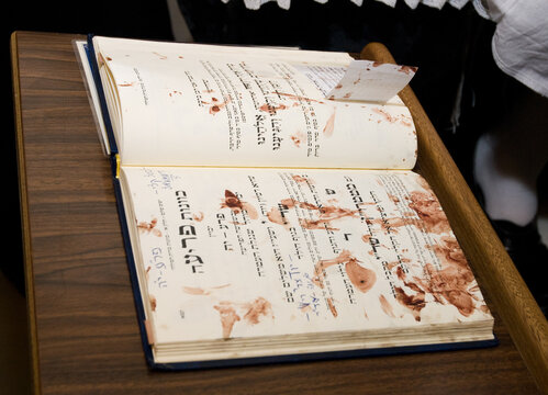 A prayer book used by a mohel or a Jewish ritual circumciser with spots of blood across two open pages.