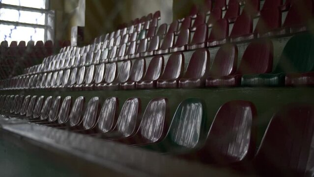 The empty seats of the stands of the old dark sports hall.