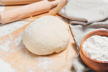 Raw dough with flour on table